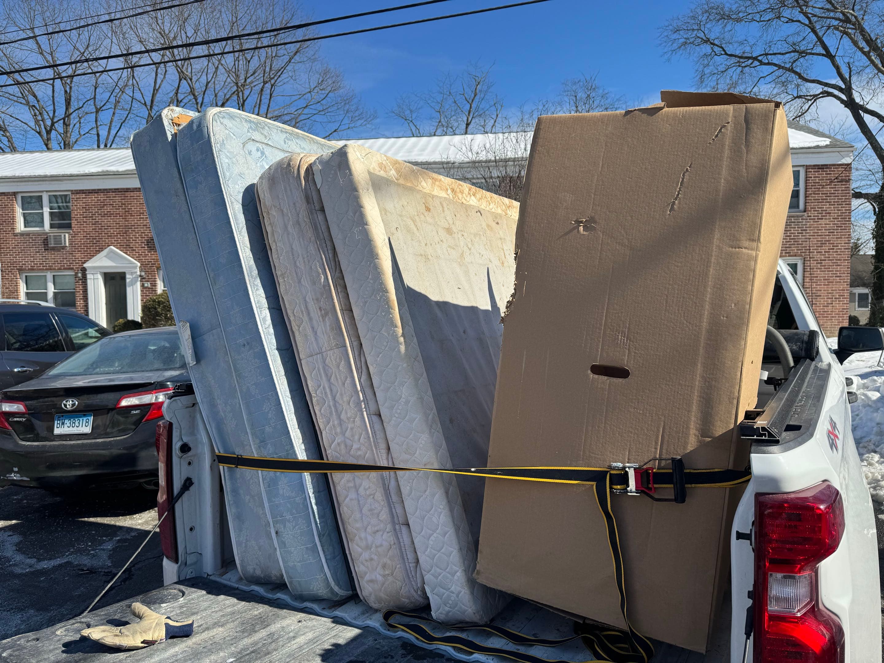 Multiple mattresses loaded in truck for removal